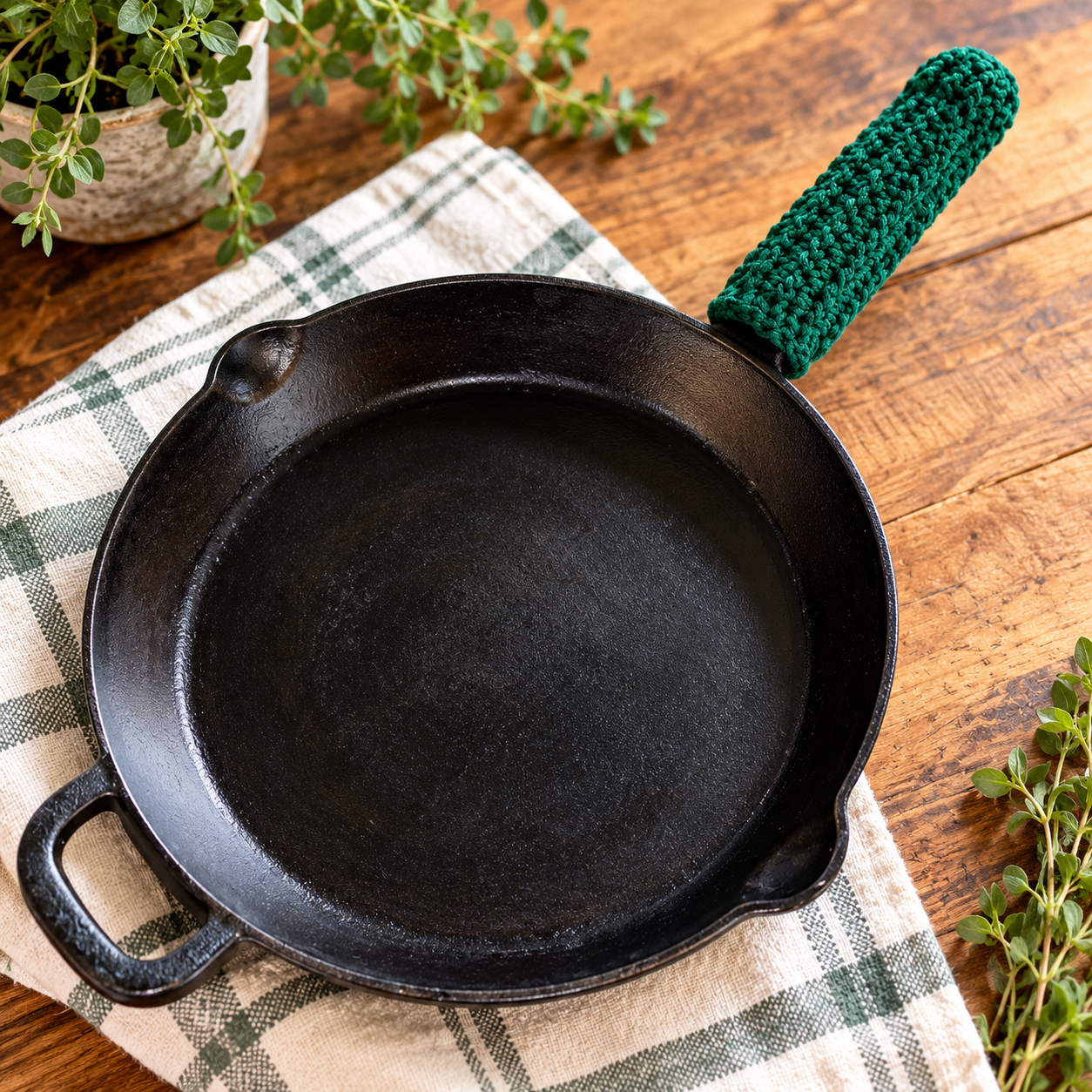 Forest green cotton crochet skillet snuggie fitted over a cast iron skillet handle